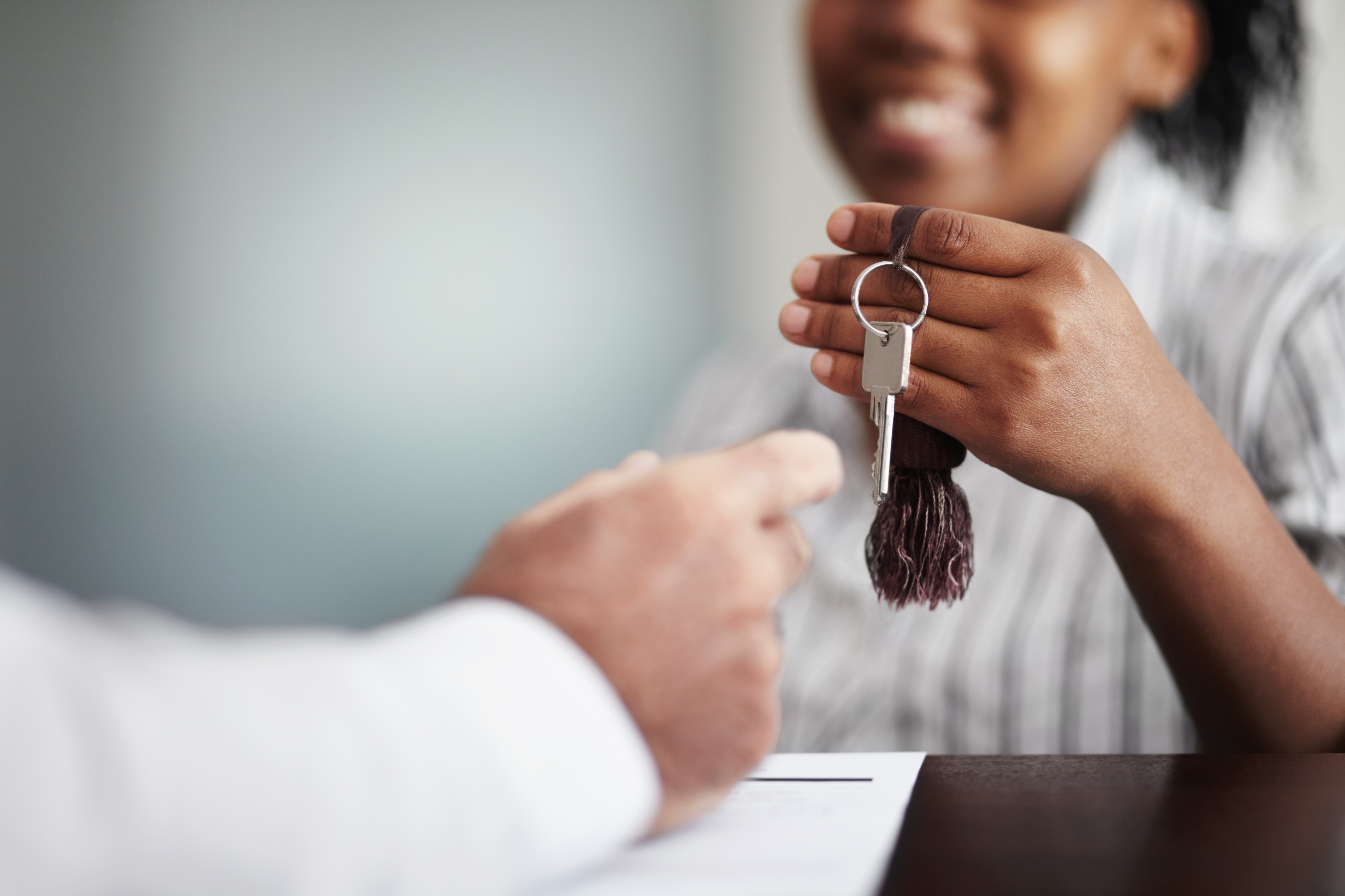 Woman Handing Over a Set of Keys