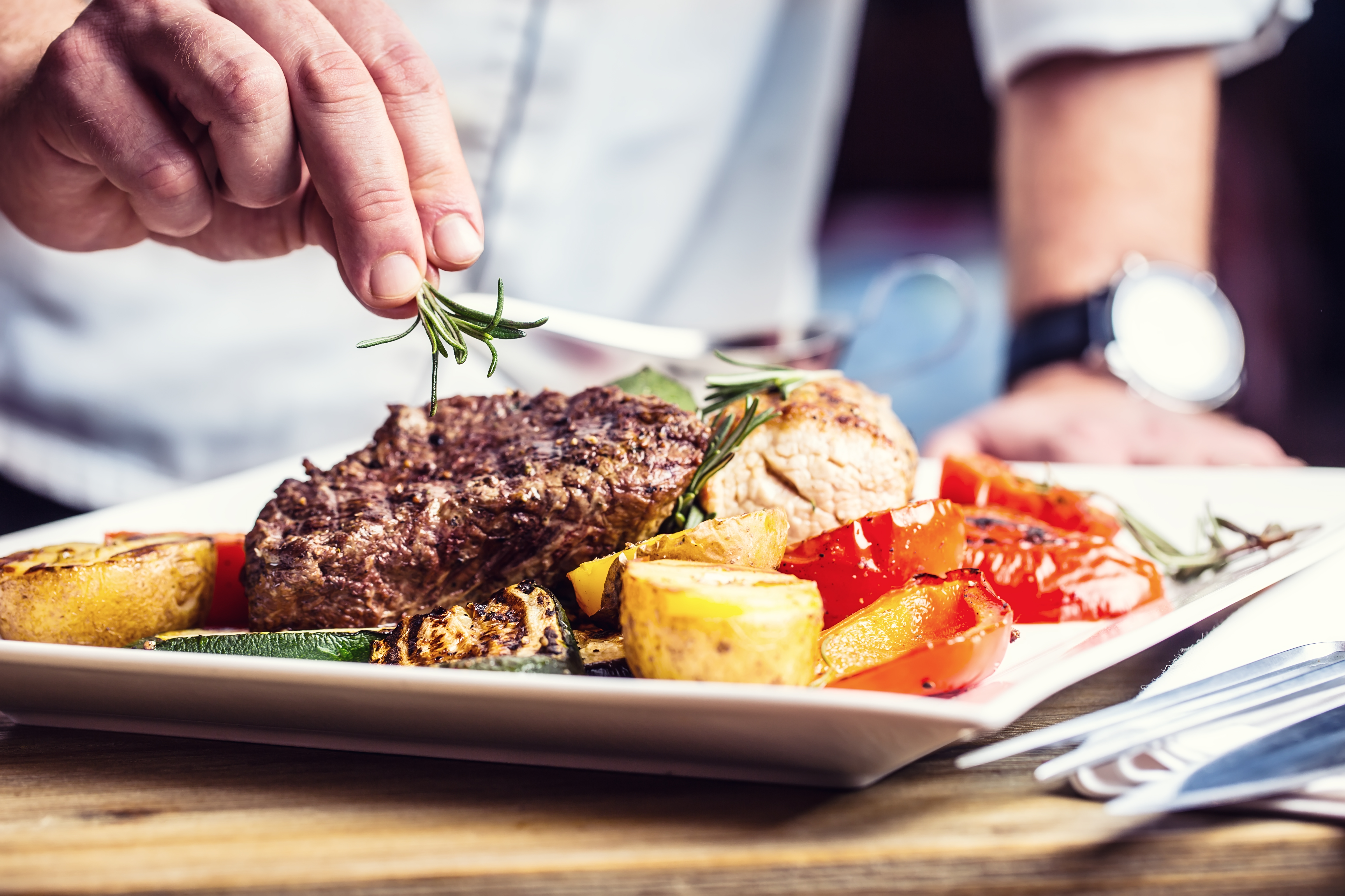 Chef in hotel or restaurant kitchen cooking only hands.