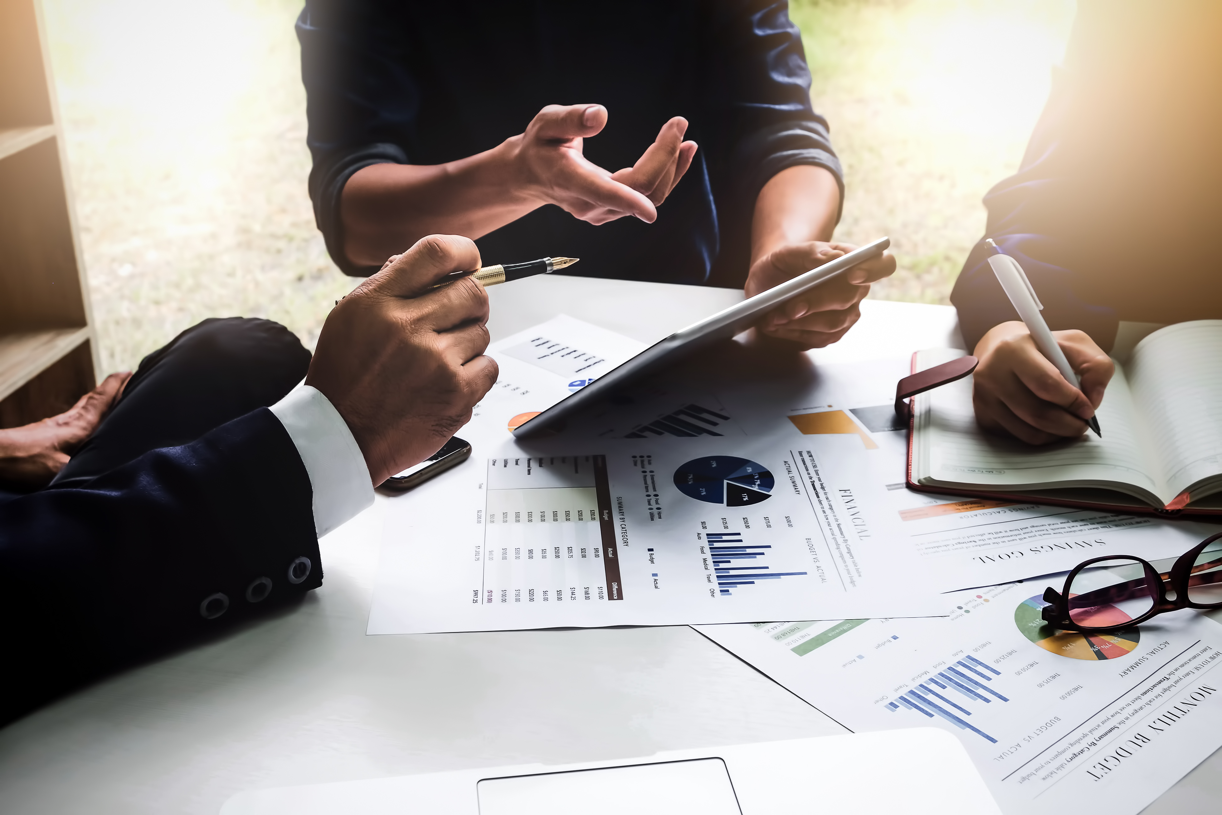 Business people using pen, tablet, notebook are planning a marketing plan